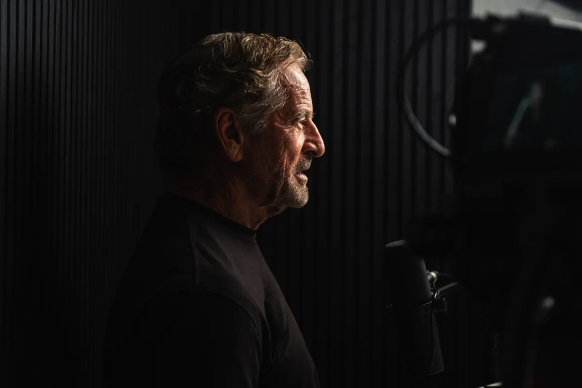 Mark Bouris in profile, speaking into a studio microphone